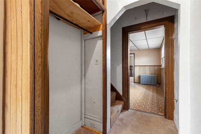 corridor featuring light tile floors and radiator heating unit