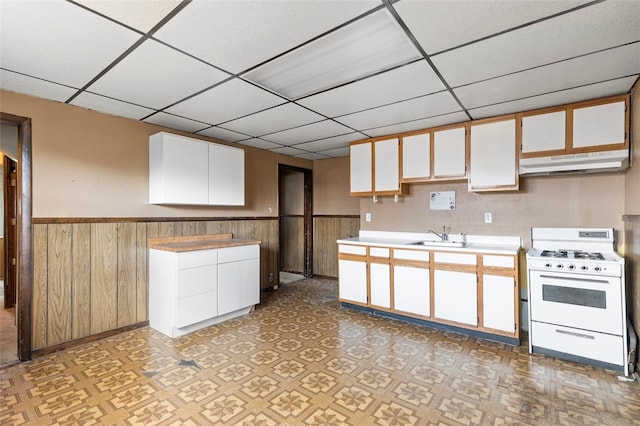 kitchen with a paneled ceiling, white cabinetry, white range with gas stovetop, and sink