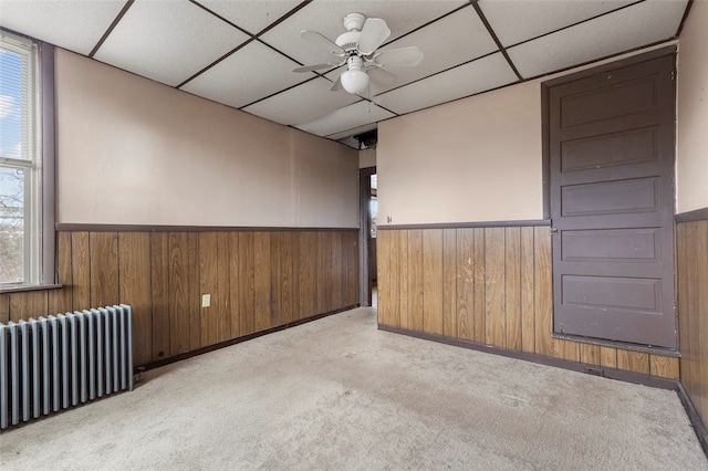 spare room featuring ceiling fan, radiator, a healthy amount of sunlight, and light carpet