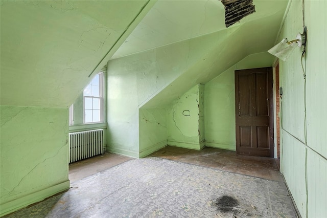 additional living space featuring lofted ceiling and radiator heating unit