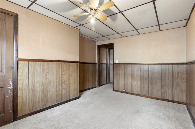 spare room featuring light carpet, ceiling fan, and a drop ceiling