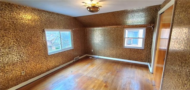 bonus room featuring vaulted ceiling, hardwood / wood-style flooring, and a healthy amount of sunlight