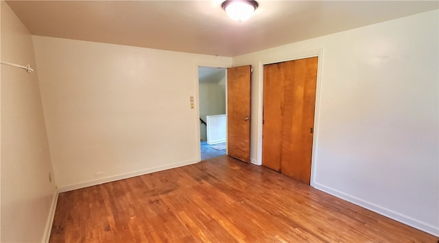 unfurnished bedroom featuring wood-type flooring and a closet