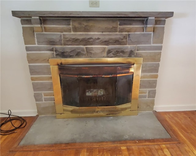 details featuring a stone fireplace and hardwood / wood-style floors