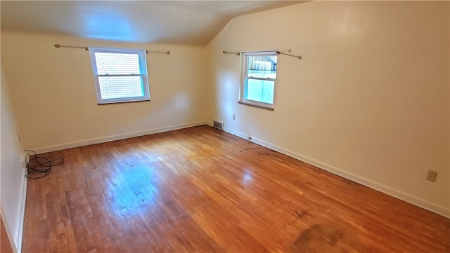 bonus room with wood-type flooring and vaulted ceiling