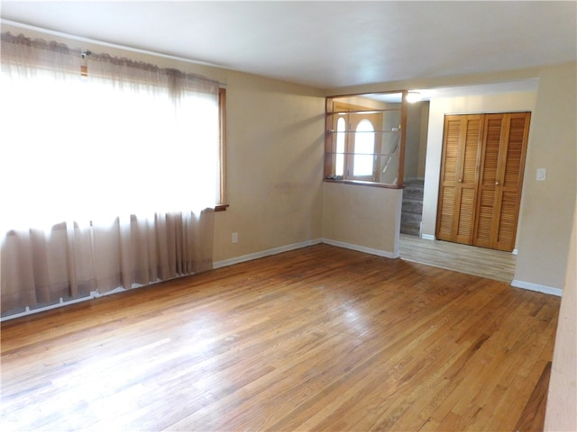 spare room with light wood-type flooring and a wealth of natural light