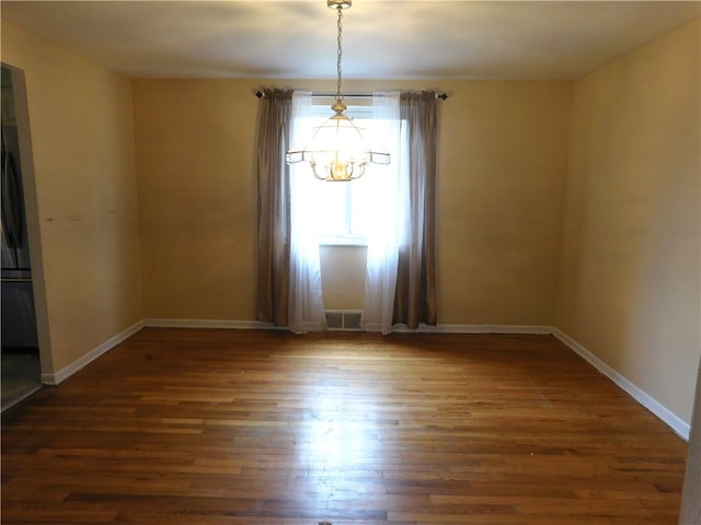 unfurnished room featuring dark hardwood / wood-style floors and a chandelier