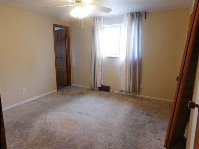 carpeted spare room featuring ceiling fan