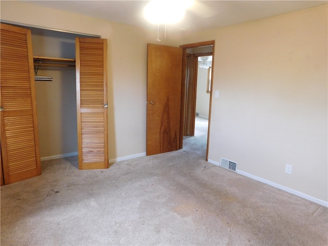 unfurnished bedroom with a closet and light colored carpet