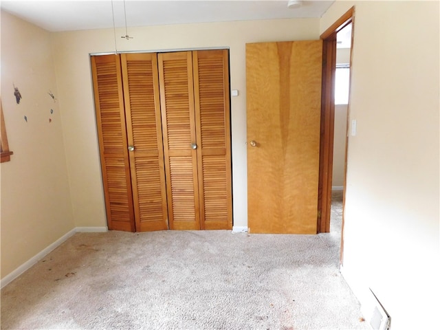 unfurnished bedroom featuring a closet and light colored carpet