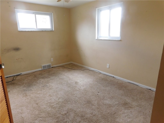 carpeted spare room featuring ceiling fan