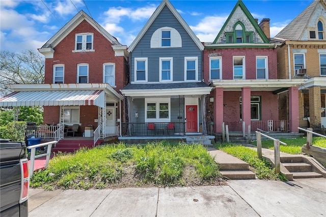 townhome / multi-family property featuring covered porch