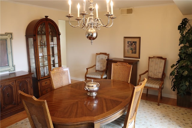 dining area featuring light hardwood / wood-style floors, a chandelier, and ornamental molding