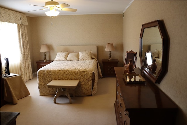 carpeted bedroom featuring ornamental molding and ceiling fan