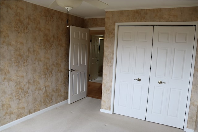 unfurnished bedroom featuring ceiling fan, a closet, and carpet flooring