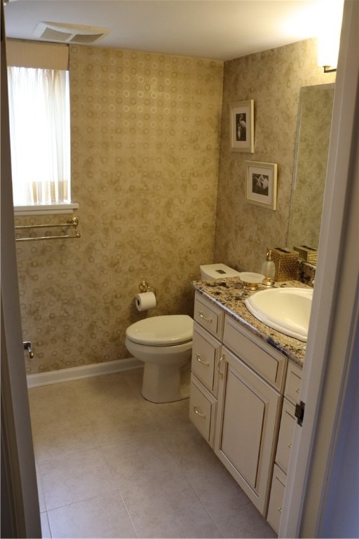 bathroom featuring tile patterned flooring, toilet, and vanity