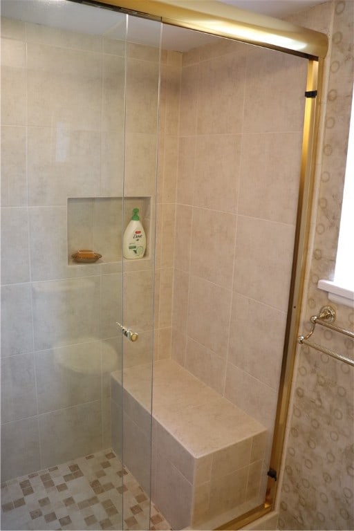 bathroom featuring a shower with door