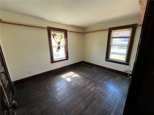 empty room with dark hardwood / wood-style flooring