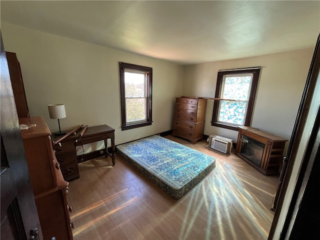 bedroom with hardwood / wood-style floors and multiple windows