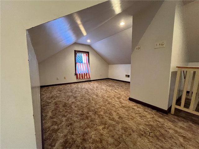 bonus room with lofted ceiling and dark carpet