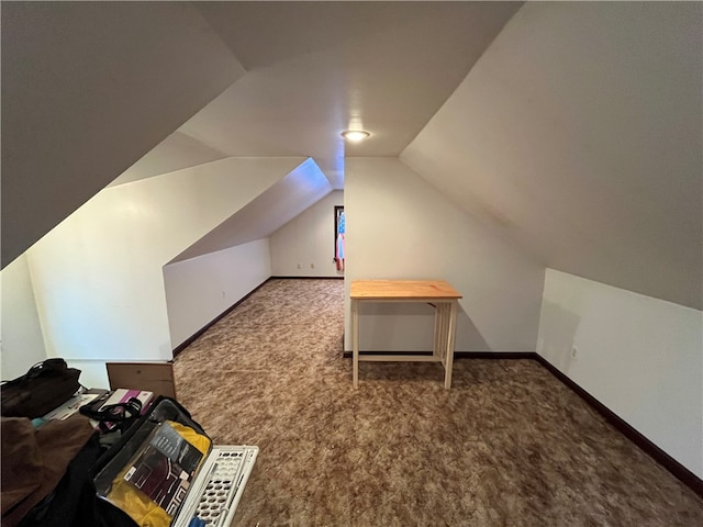 additional living space with vaulted ceiling and dark carpet