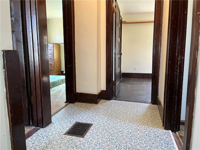 hallway featuring dark tile flooring