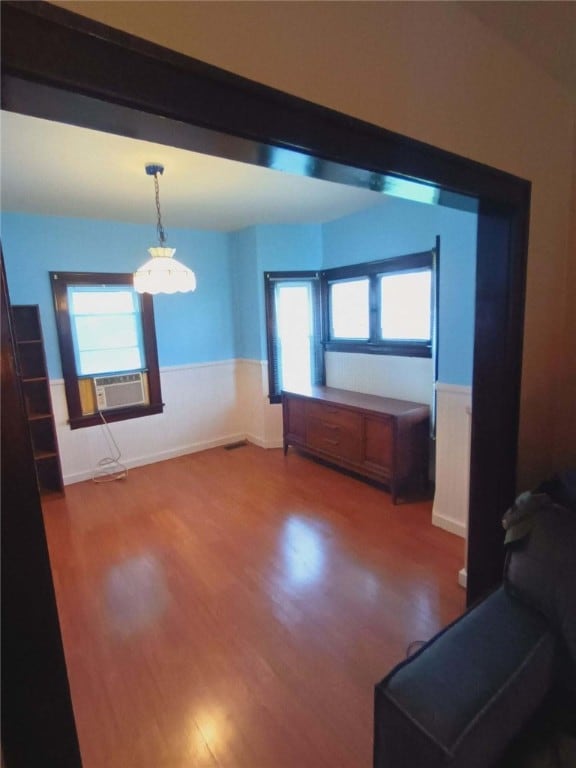 unfurnished living room with an inviting chandelier and dark wood-type flooring