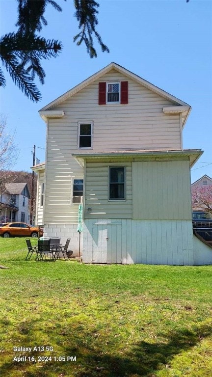 rear view of property with a lawn