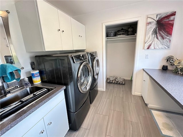 clothes washing area with cabinets, separate washer and dryer, and sink