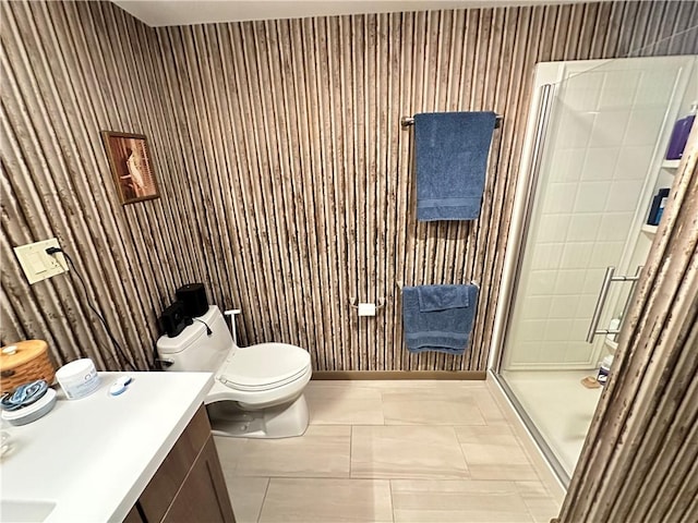 bathroom featuring tile patterned floors, vanity, toilet, and a shower with door