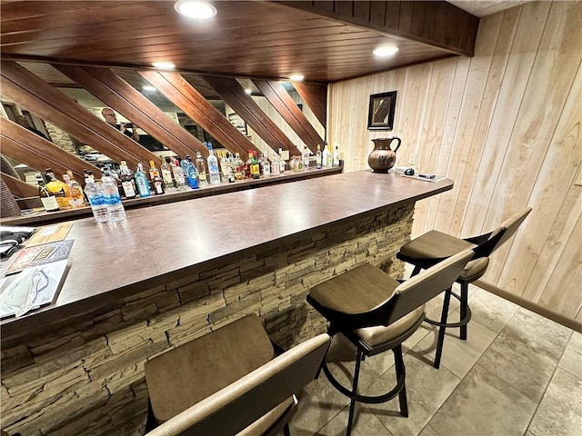 bar with wood walls, light tile patterned flooring, and wooden ceiling