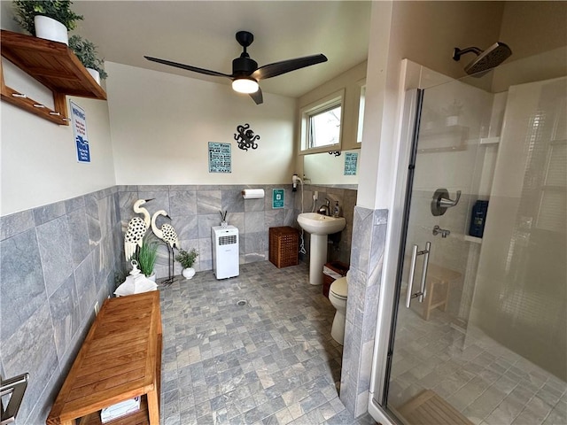 bathroom with an enclosed shower, tile walls, and toilet