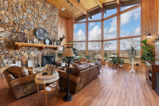 living room with wood ceiling, a fireplace, high vaulted ceiling, and wood-type flooring