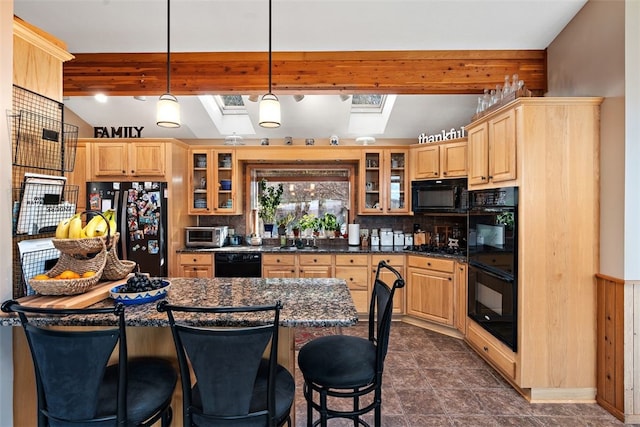 kitchen with a breakfast bar area, hanging light fixtures, tasteful backsplash, and black appliances