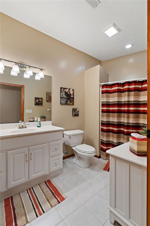 bathroom featuring vanity, tile floors, and toilet