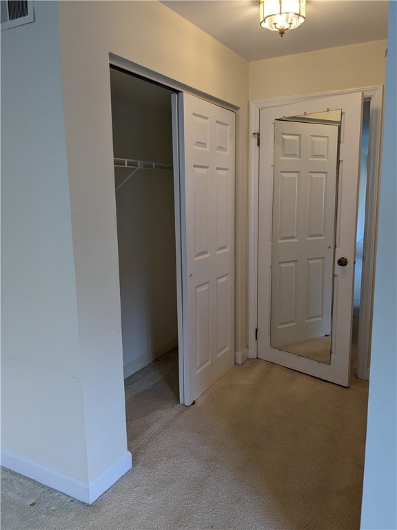 unfurnished bedroom featuring a closet and light colored carpet