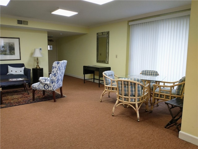 dining space with ornamental molding and carpet