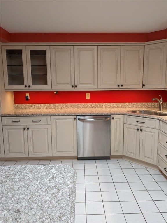 kitchen with stainless steel dishwasher, sink, and light tile flooring