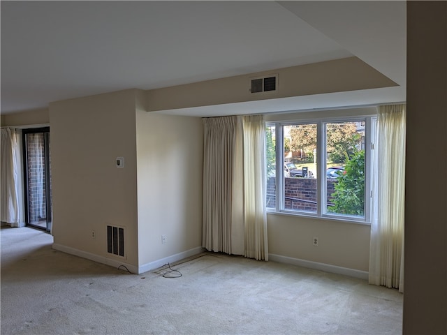 spare room featuring light carpet