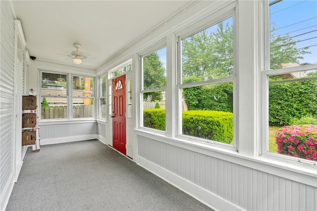 unfurnished sunroom featuring ceiling fan