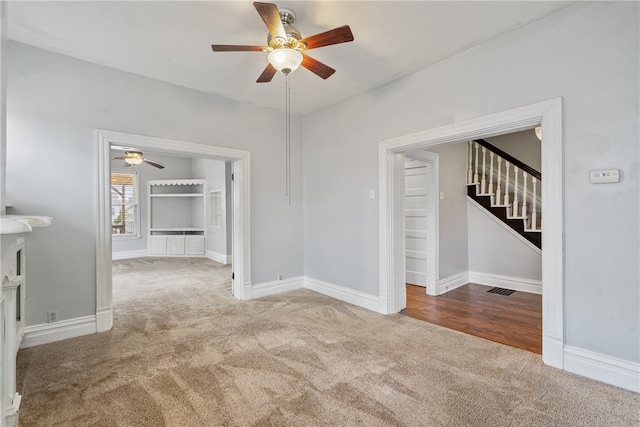 unfurnished room with ceiling fan and light carpet