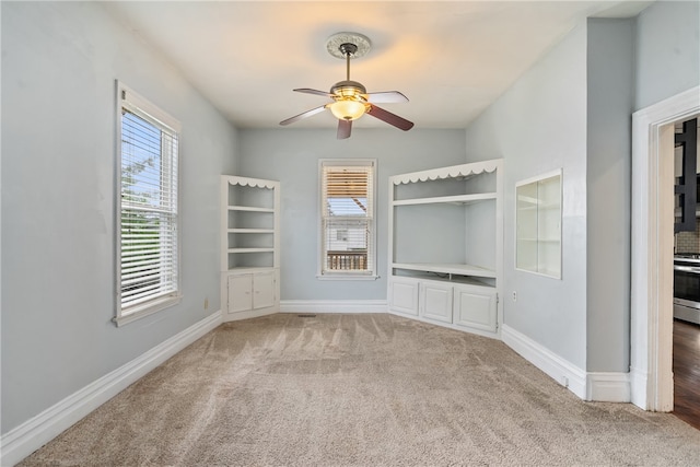 carpeted spare room featuring ceiling fan