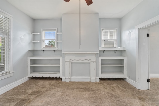 unfurnished living room with dark carpet and ceiling fan