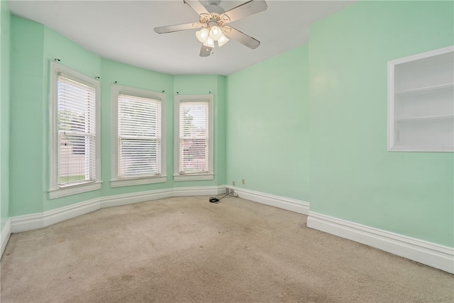 carpeted empty room with ceiling fan and a healthy amount of sunlight