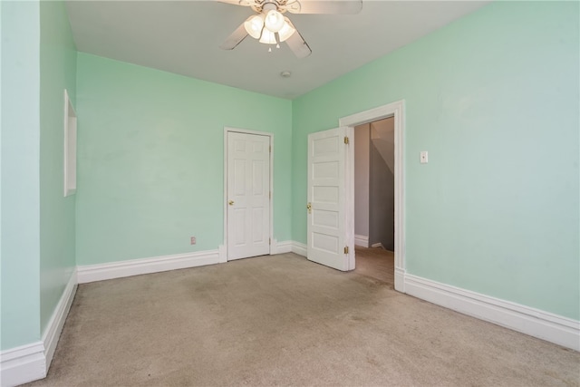 empty room featuring ceiling fan and light colored carpet