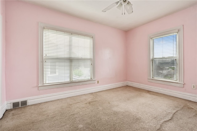 empty room featuring ceiling fan and light colored carpet