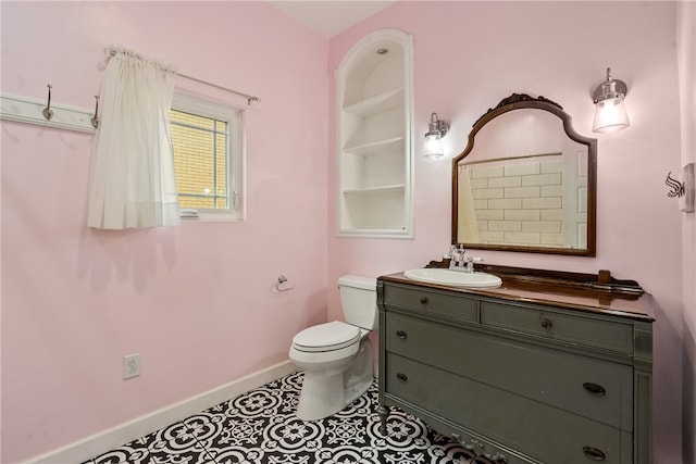 bathroom featuring toilet, tile floors, and vanity