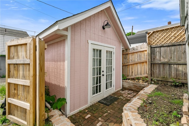 view of property exterior featuring french doors and an outdoor structure