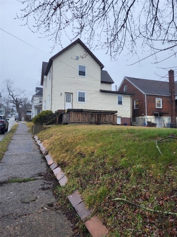 view of side of property with a yard and a deck