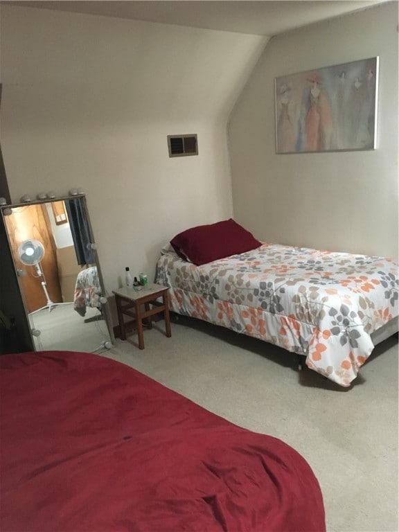 bedroom featuring lofted ceiling and light colored carpet